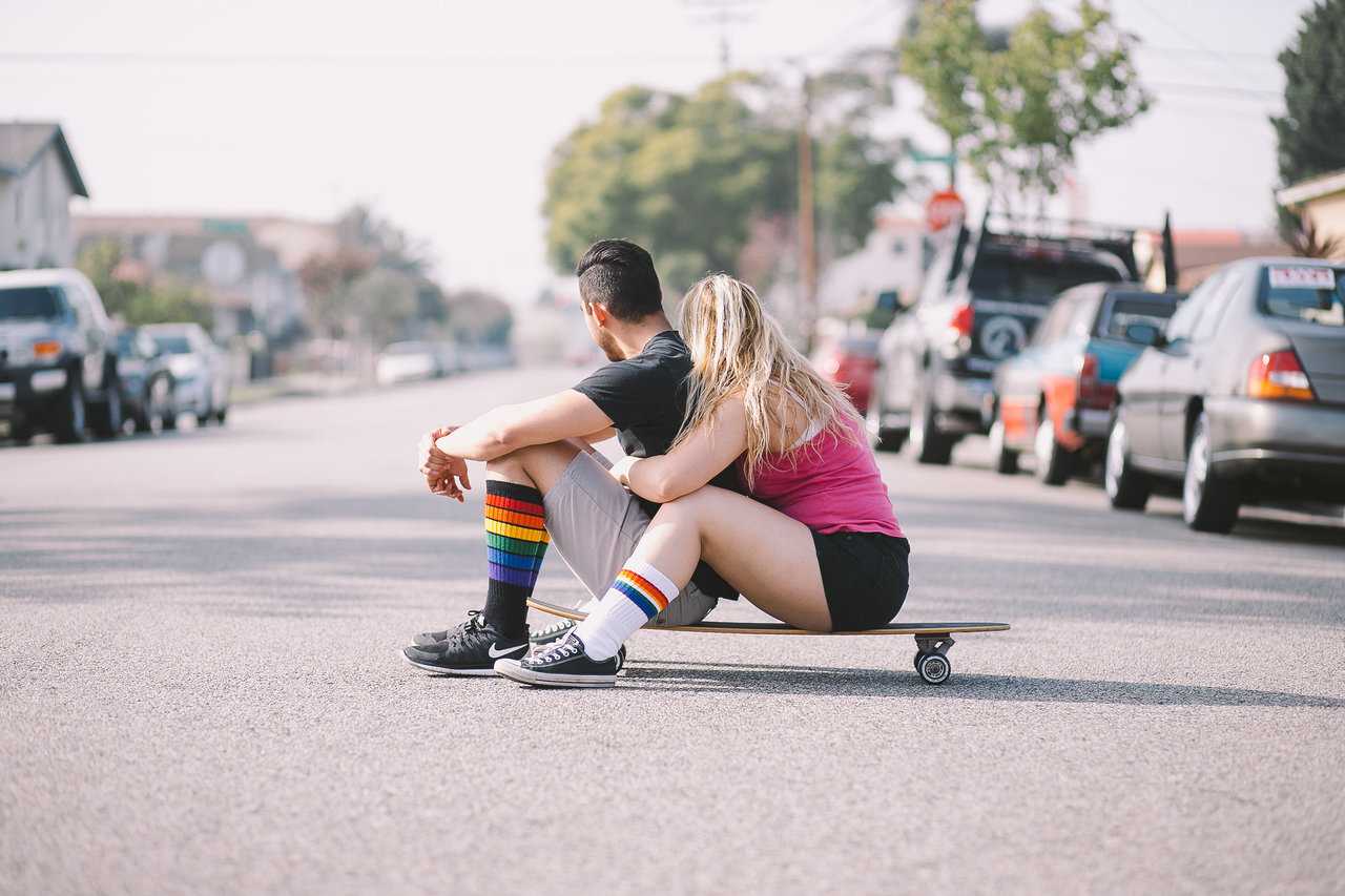 Lifestyle image of Glow rainbow tube socks with sneakers and skateboard