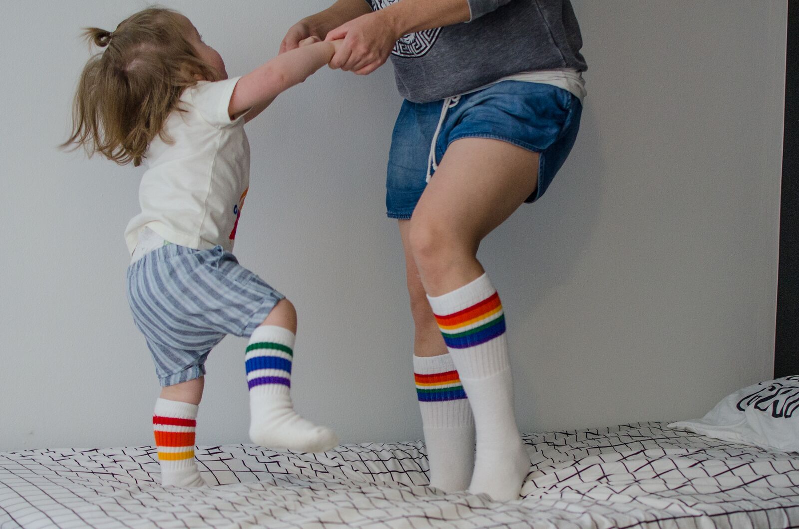 Lifestyle image of Love rainbow knee high socks with just socks as mom and son
