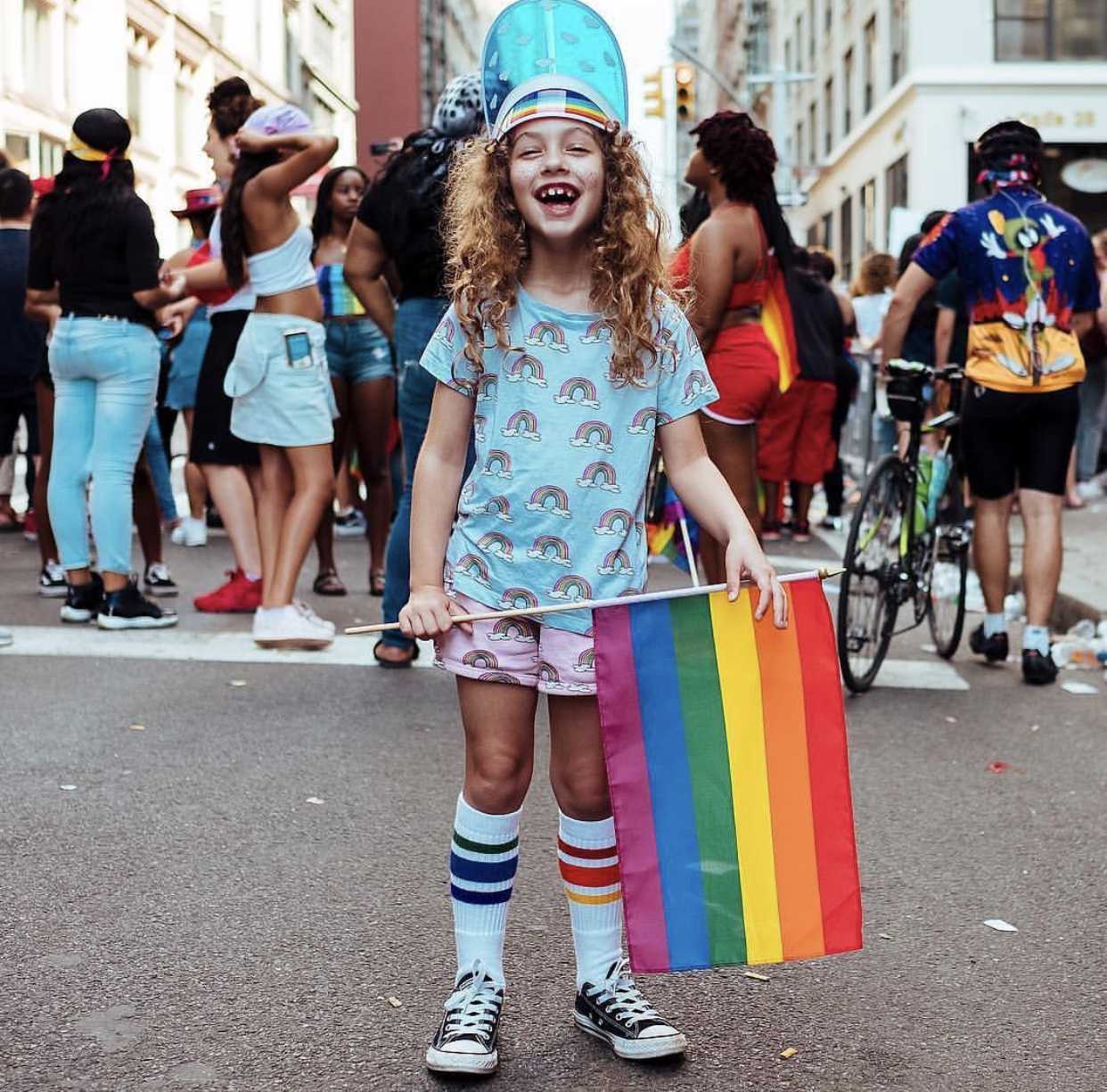 Child leaping in the air wearing socks that say ‘I’m proud to be me’