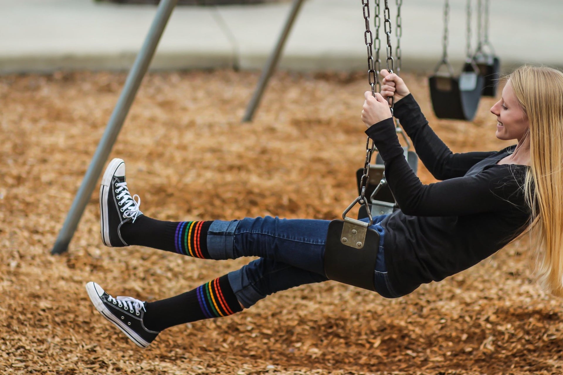 Close-up of Strength rainbow under the knee tube socks while on the swingset
