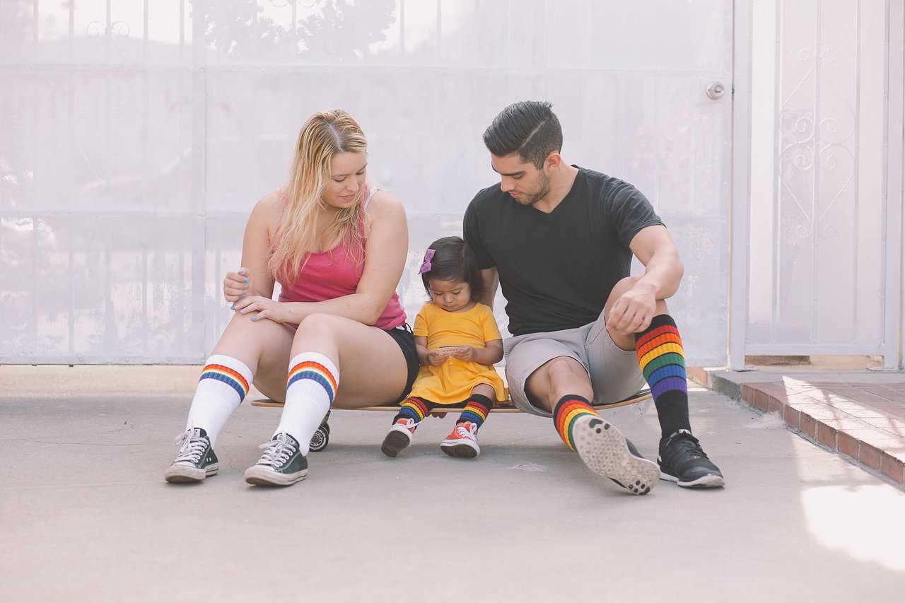 Glow rainbow knee high socks styled with casual pride outfit