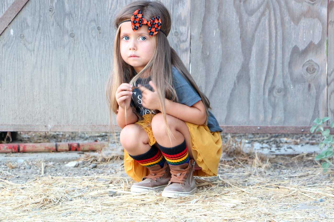 Kid playing outside in Brave rainbow tube socks