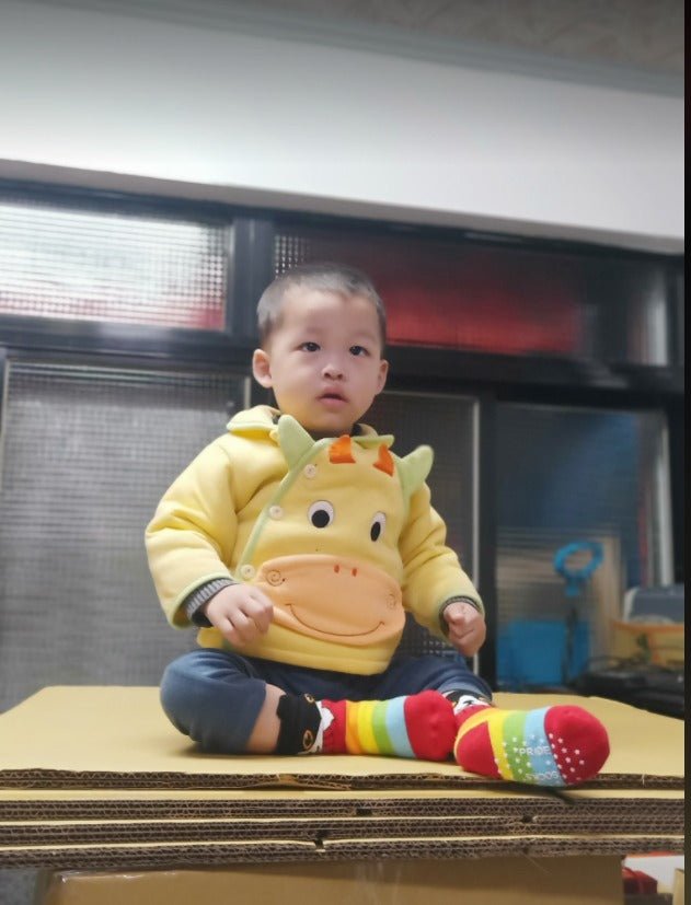 Lifestyle image of Kitty toddler grip socks hanging outside on the table