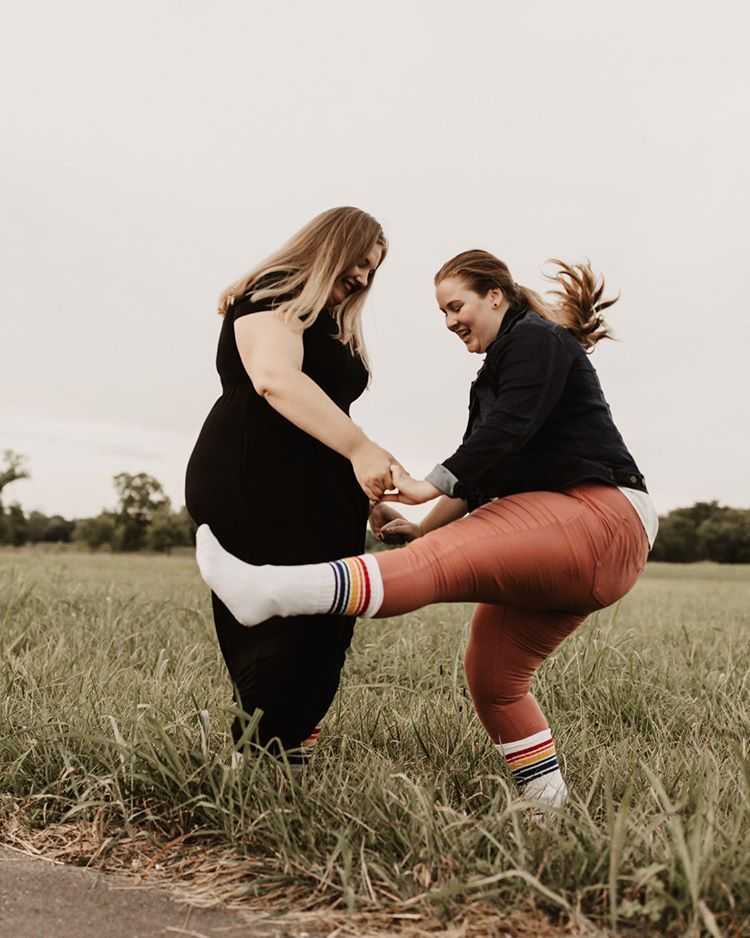 two lesbians wearing fearless rainbow socks at wedding outside