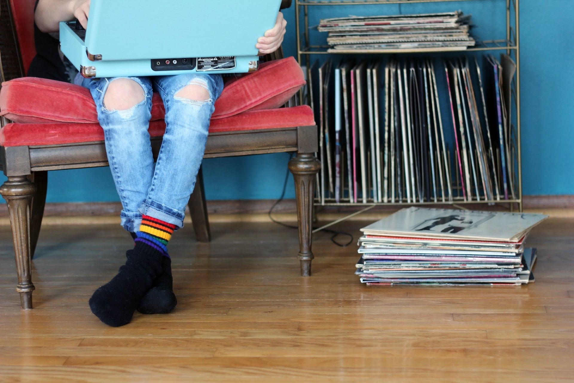 Kid wearing Brave rainbow tube socks indoors listening to old school records.