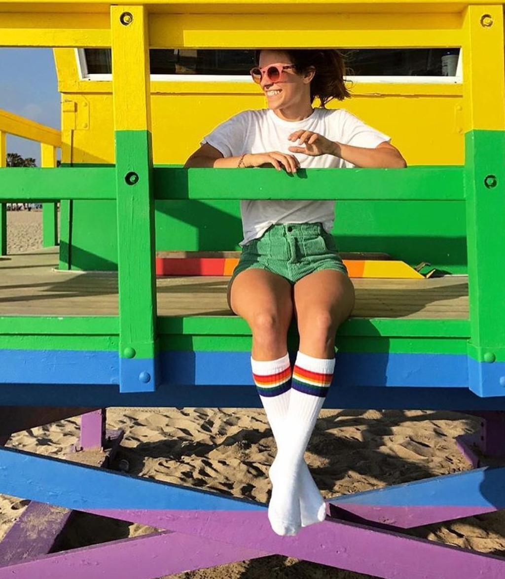 Close-up of Love rainbow knee high tube socks by Pride Socks in Venice Beach, CA on the rainbow lifeguard tower