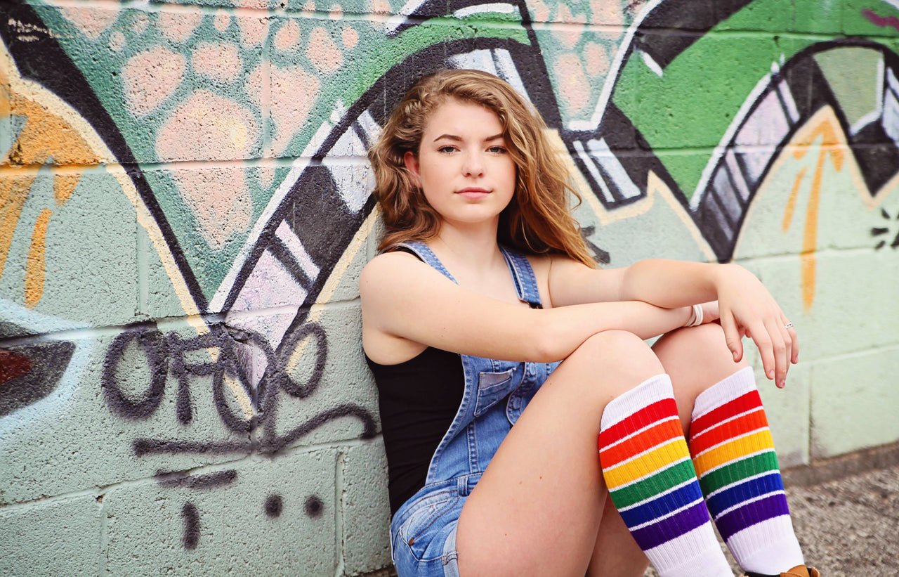 YOLO - Knee High Tube Socks by Pride Socks by a graffati wall